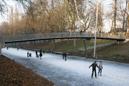 900016 Afbeelding van schaatsers op de bevroren Stadsbuitengracht te Utrecht ter hoogte van de St. Martinusbrug.